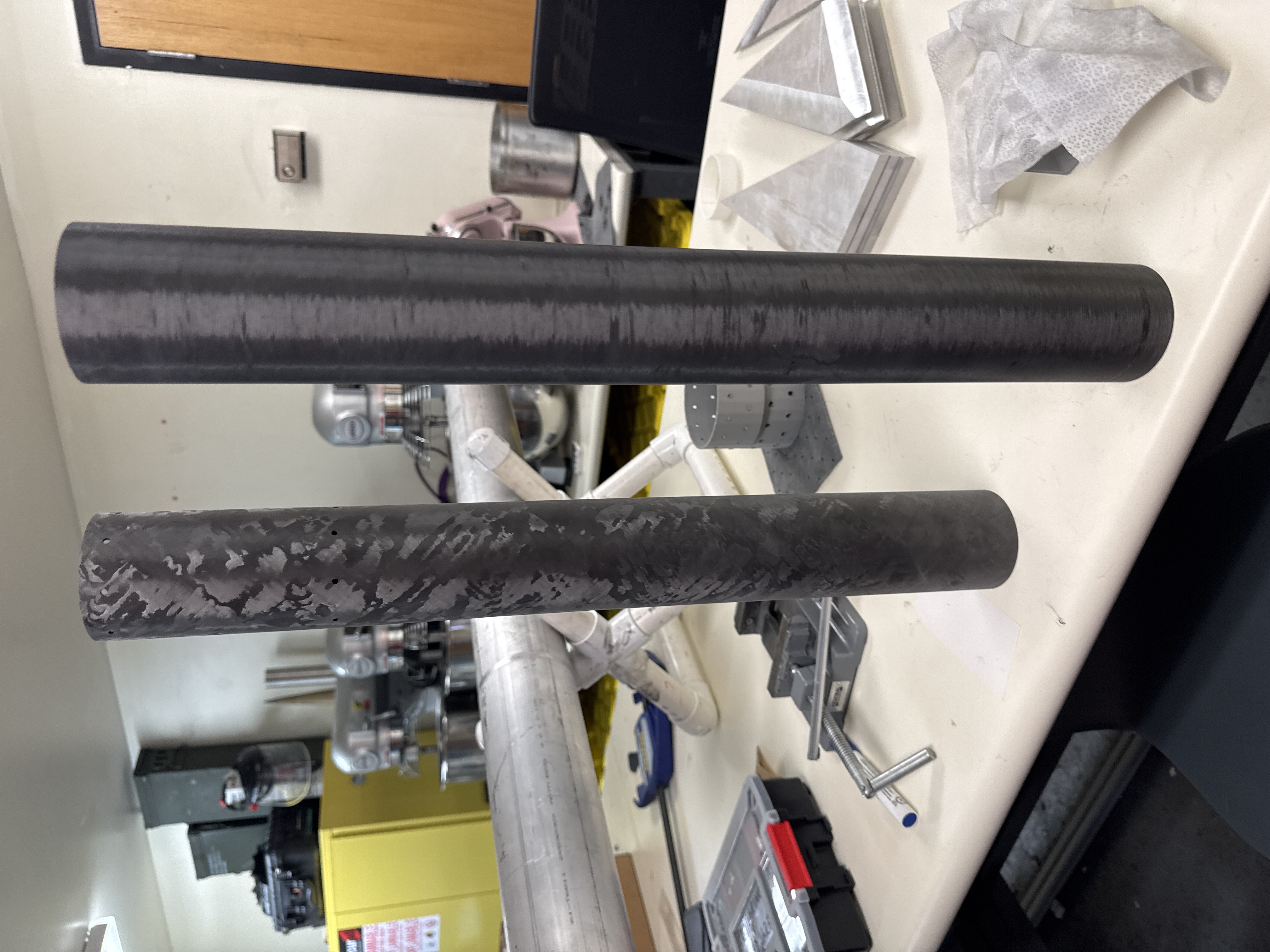 Surface-finished composite airframe components standing on a workbench.