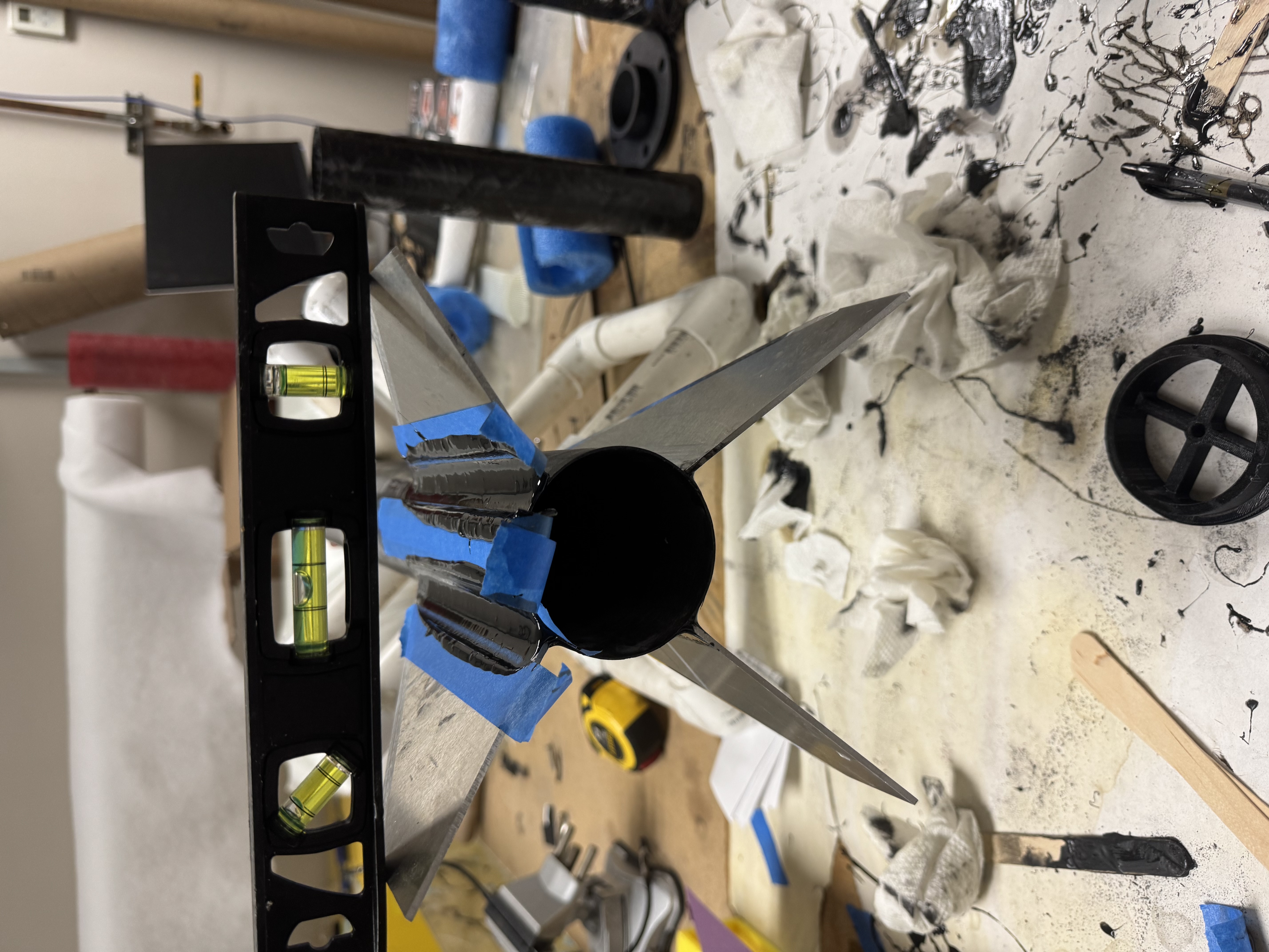 Rocket fins during assembly with a spirit level across them.